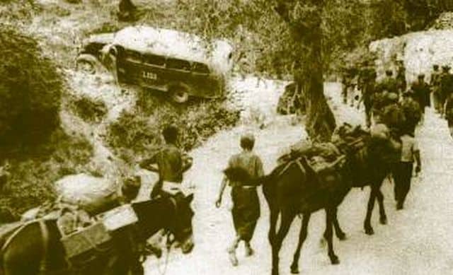 Ιταλοί ημιονηγοί μεταφέρουν με τα μουλάρια τους πυρομαχικά. Στο βάθος κατεστραμμένο λεωφορείο